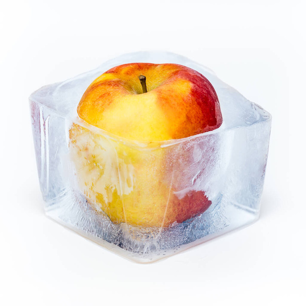 Red apple frozen in the ice cube - Фото, зображення