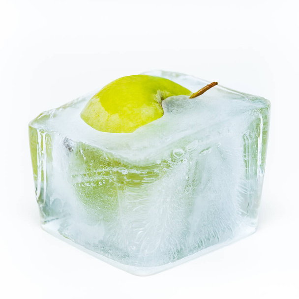Green apple frozen in the ice cube - Photo, Image