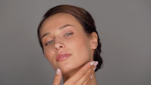 beautiful young woman touching her face - Filmati, video