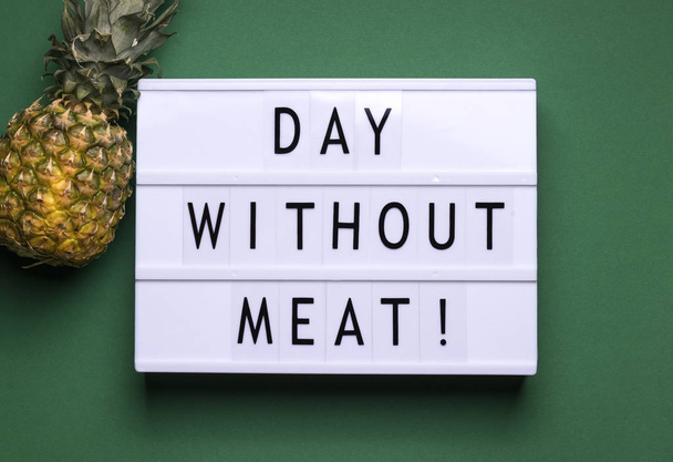 on a green background there is a lightbox with text and a fruit announcement next to it. International Day Without Meat concept - Zdjęcie, obraz