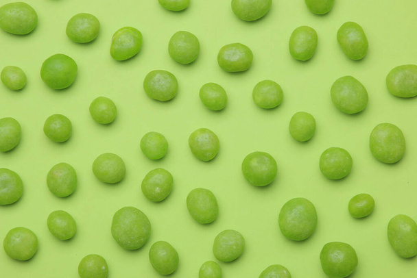 O conceito de minimalismo. fundo de deliciosos doces verdes brilhantes em um fundo verde brilhante. vista superior
. - Foto, Imagem