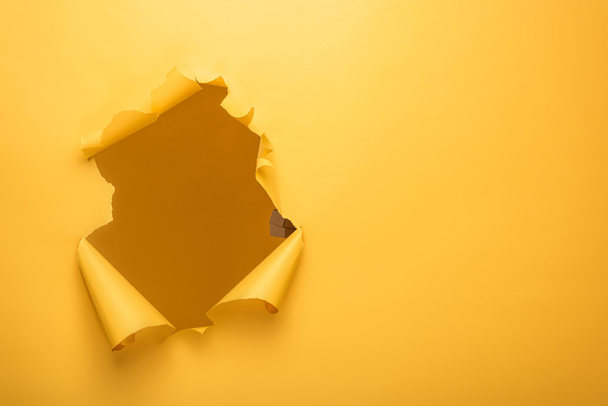 agujero roto en la textura de papel amarillo con espacio de copia
 - Foto, Imagen