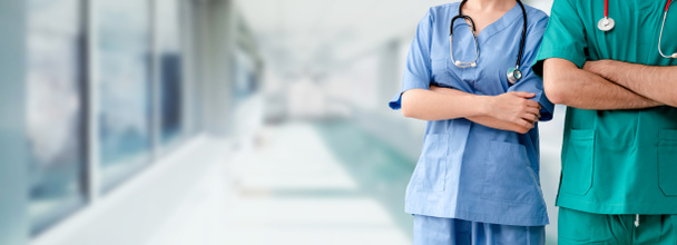 Δύο νοσηλευτικό προσωπικό - χειρουργός, γιατρός ή νοσοκόμα στέκεται με τα χέρια σταυρωμένα στο νοσοκομείο. Ιατρική περίθαλψη και ιατρική περίθαλψη. - Φωτογραφία, εικόνα