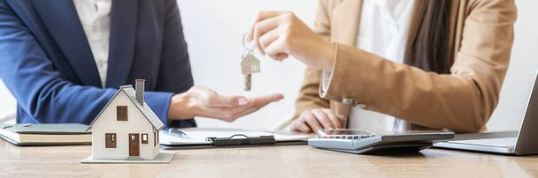 Immobilienmakler, der einen Schlüssel hält und den Kunden um einen Vertrag bittet, um Immobilien oder Immobilien zu kaufen, zu versichern oder zu verleihen. - Foto, Bild