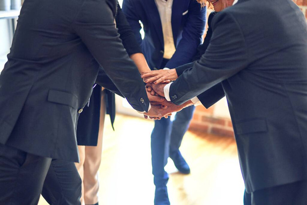 Grupo de trabajadores de negocios de pie en un círculo con las manos juntas en la oficina
. - Foto, imagen