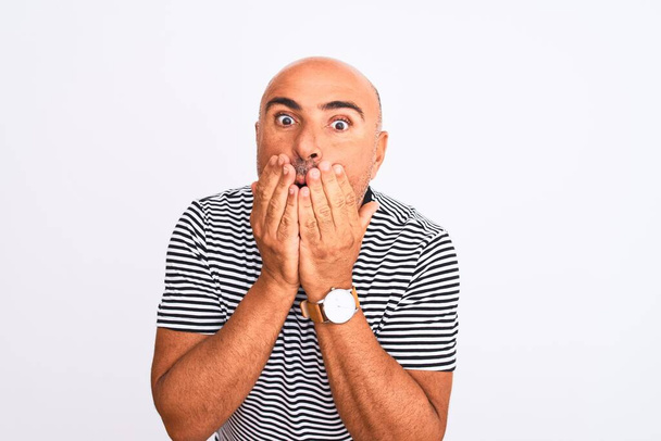 Middle age handsome man wearing striped navy t-shirt over isolated white background shocked covering mouth with hands for mistake. Secret concept. - Photo, Image