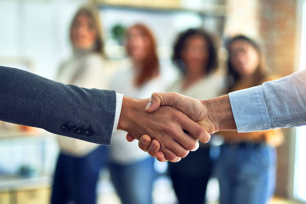 Gruppe von Geschäftsleuten steht zusammen und schüttelt Hände im Büro - Foto, Bild