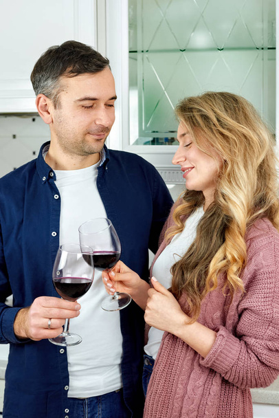 Ζευγάρι κρατώντας ποτήρια κρασί στην κουζίνα - Φωτογραφία, εικόνα