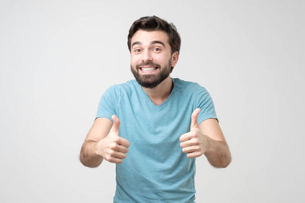 Щасливий іспаномовний чоловік з великими пальцями вгору жестом, схвалюючи свій вибір. Позитивні людські емоції обличчя
. - Фото, зображення