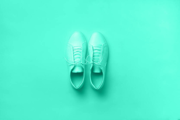 Stylish white sneakers and rope on mint color background with copy space. Top view. Minimal flat lay. Summer shoes collection. Trendy green and turquoise color. - Foto, imagen