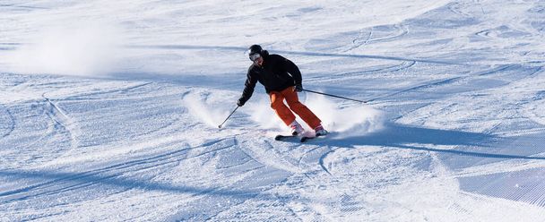 Bulgária. Bansko. 10 de fevereiro de 2020. Esquiador descendo o enorme campo de neve salpicando neve em pó
 - Foto, Imagem