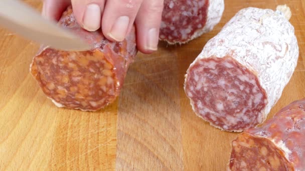 cutting italian salami sausage into slices on a wooden cutting board 4k - Footage, Video