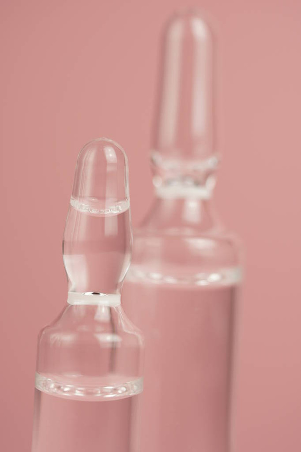 Ampolas médicas de vidro em um fundo rosa close-up, espaço de cópia, foco seletivo
. - Foto, Imagem