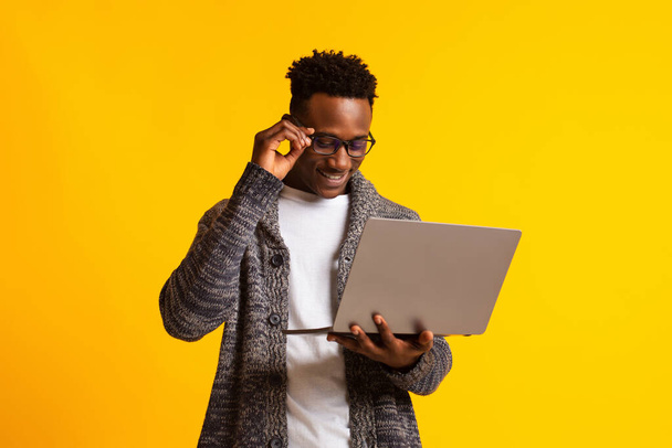 Programador de homem americano africano com laptop em amarelo
 - Foto, Imagem