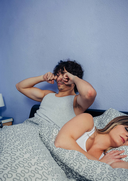 Мужчина просыпается, пока его жена спит
 - Фото, изображение
