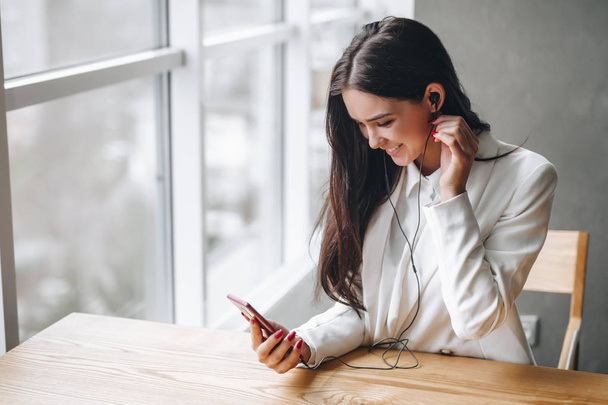 Frau hört Musik am Tisch mit Kopfhörern - Foto, Bild