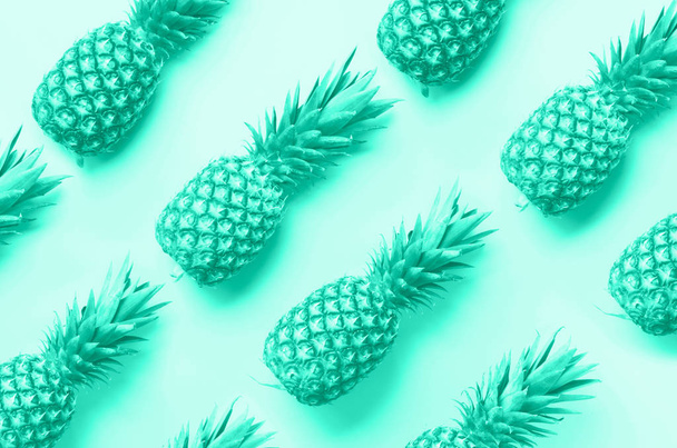 Fresh pineapples on mint color background. Top View. Pop art design, creative concept. Trendy green and turquoise color. Bright pineapple pattern for minimal style. - Foto, Imagem