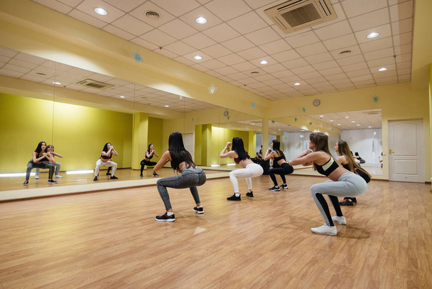 A group of young girls are engaged in fitness under the guidance of an experienced coach. Fitness, healthy lifestyle. - Foto, Imagen