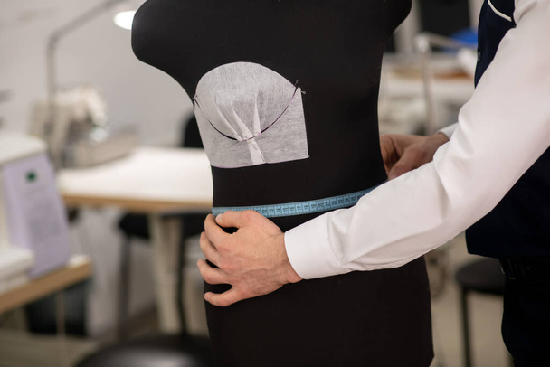 Hands of male fashion designer measuring dummy waist - Fotoğraf, Görsel