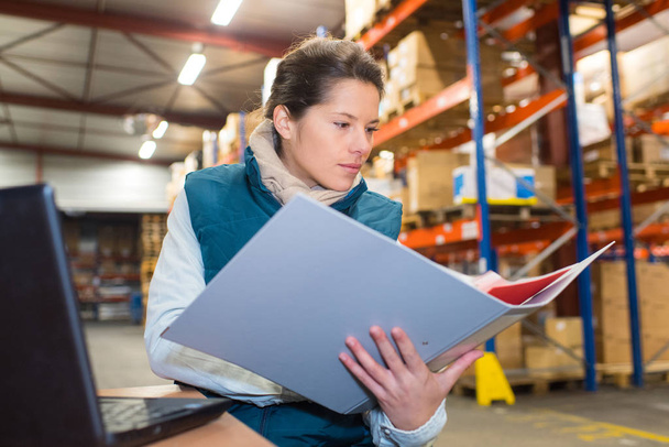 female warehouse manager with file folder in warehouse - Foto, Imagem