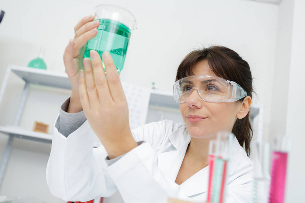 female lab worker holding flask - Φωτογραφία, εικόνα