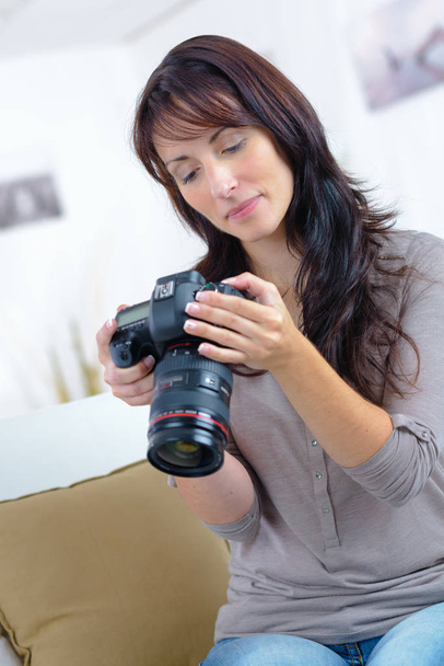 photographer holding camera and checking photos - Foto, imagen