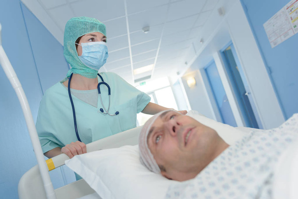 orvos orvosi egyenruhában szállítja a beteget a műtőbe - Fotó, kép