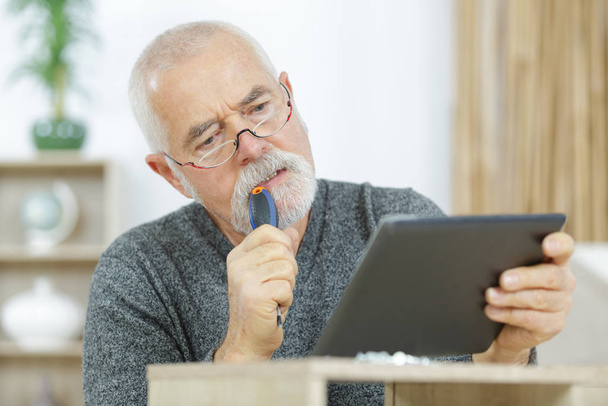 senior relaxing with entertainment on tablet - Photo, Image