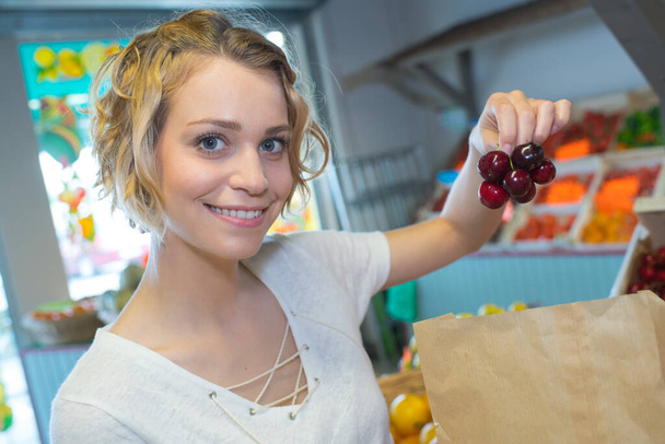 young woman buying fruits at a weekly market - 写真・画像