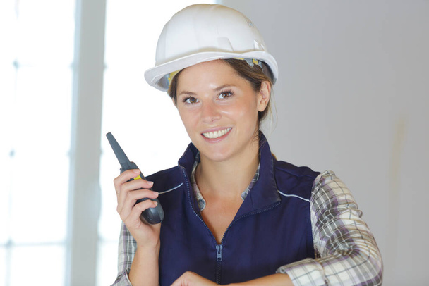 portrait of female builder holding a walkie talkie - 写真・画像