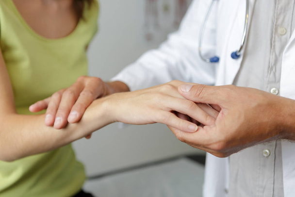 doctors hand checking female patient finger - Photo, Image