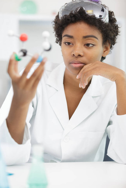 female lab worker holding a medical dna figure - Φωτογραφία, εικόνα