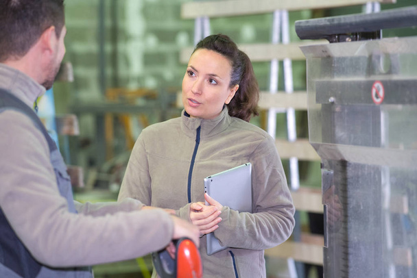 female manager talking to assistant manager in modern factory - Photo, image