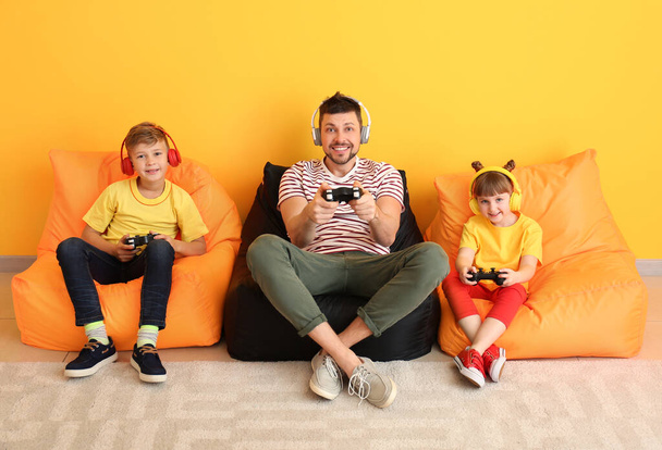 Papà e i suoi bambini che giocano ai videogiochi a casa
 - Foto, immagini