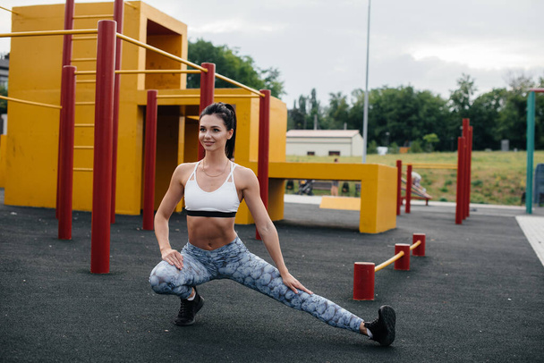 Sexy girl performs warm-up in the open air. Fitness. Healthy lifestyle - Photo, Image