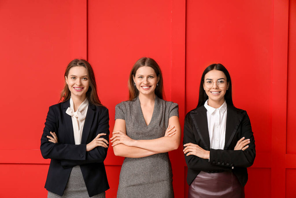 Schöne junge Geschäftsfrauen auf farbigem Hintergrund - Foto, Bild