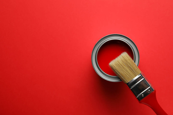 Paint can and brush on red background, top view - Photo, Image