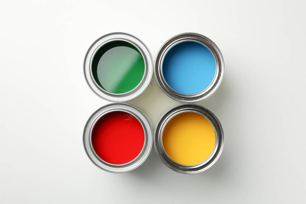 Cans of different paints on white background, top view - Фото, зображення