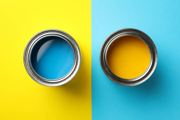 Κονσερβοκούτια μπλε και κίτρινο χρώμα σε φόντο δύο τόνων, κορυφαία άποψη - Φωτογραφία, εικόνα