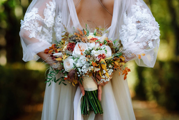 Свадебный букет невесты в женских руках. свадебные цветы
 - Фото, изображение