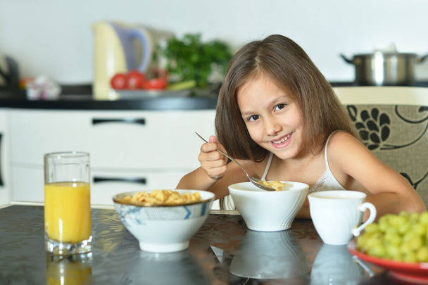 young girl eating   in the kitchen - Valokuva, kuva