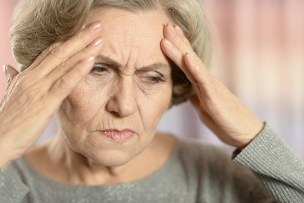 gyönyörű idős nő fejfájással  - Fotó, kép