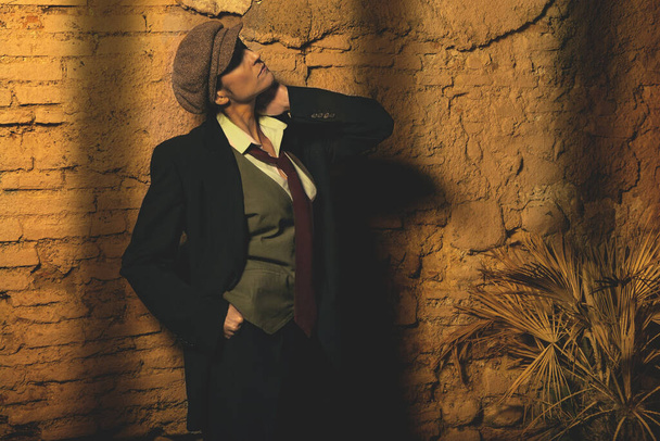Модель, одетая в мужскую одежду в стиле ретро, позирует ночью
 - Фото, изображение