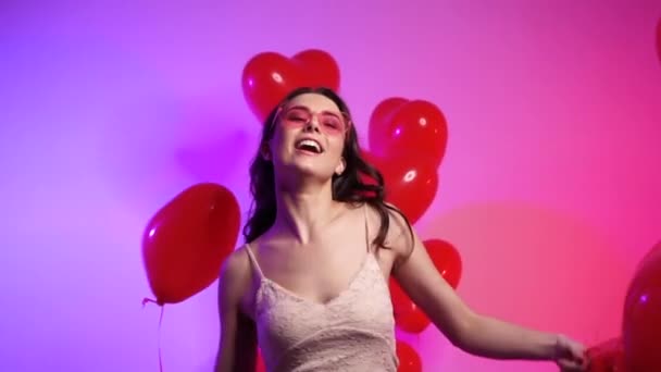 Joyful woman with heart shaped balls dancing. - Video
