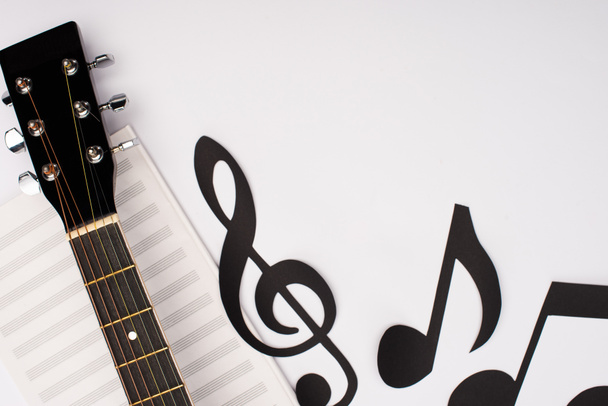 Top view of paper cut notes near music book and acoustic guitar on white background - Фото, зображення