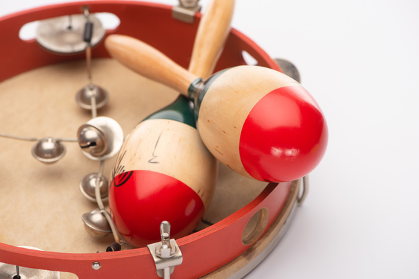 Close up view of wooden maracas on tambourine on white background - Photo, Image