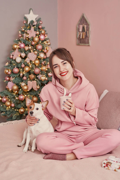 クリスマスの背景に犬ジャック・ラッセル・テリアと女の子。クリスマスカードのテンプレート。クリスマスだ。メリークリスマスと幸せな新年のコンセプト、テキストのためのスペース。中国の暦新年のコンセプト. - 写真・画像