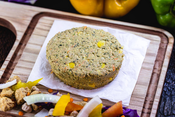 Vegan dessert or snack. Meatless hamburger based on various vegetables, seeds and protein, such as soybeans, chickpeas, tomatoes, onions, red cabbage, peppers and others. Vegan life. - Photo, Image