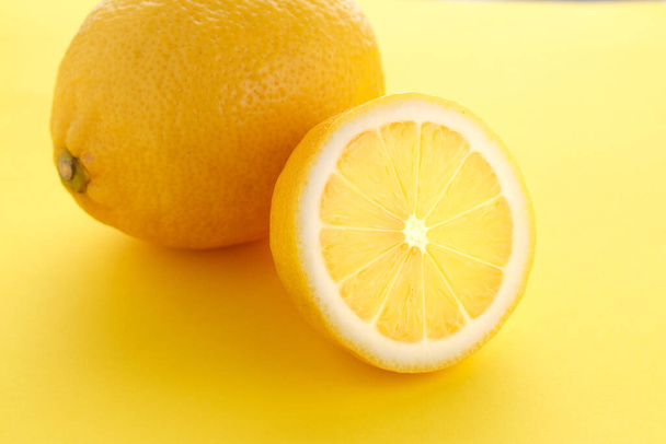gesneden heldere sappige citroen op een gele achtergrond. - Foto, afbeelding