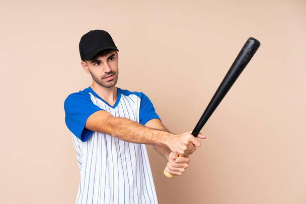 Young man over isolated background playing baseball - Foto, Imagem